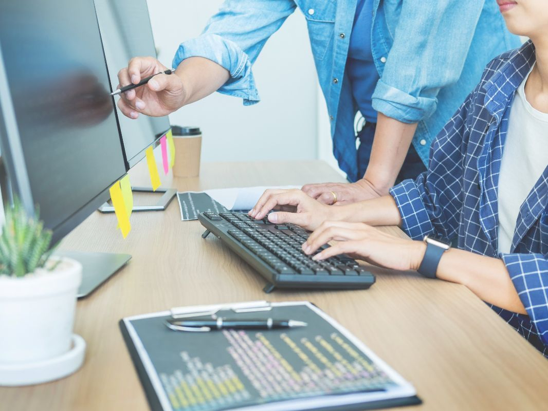 Dos trabajadores en oficina usando ordenador